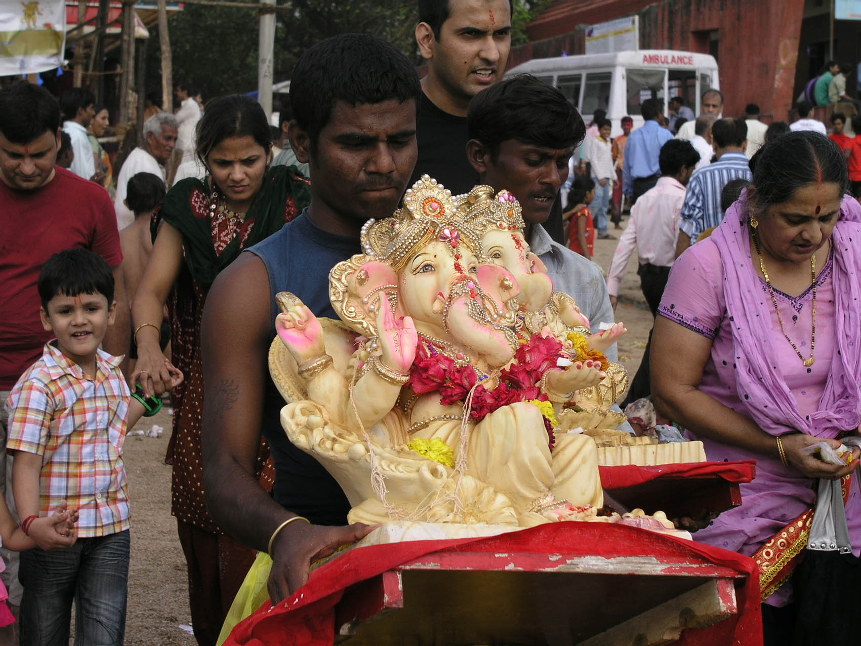 Volunteers carrying Ganesh idols out into the Arabian Sea